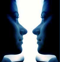If you focus on the white space between the faces you may detect a goblet or vase